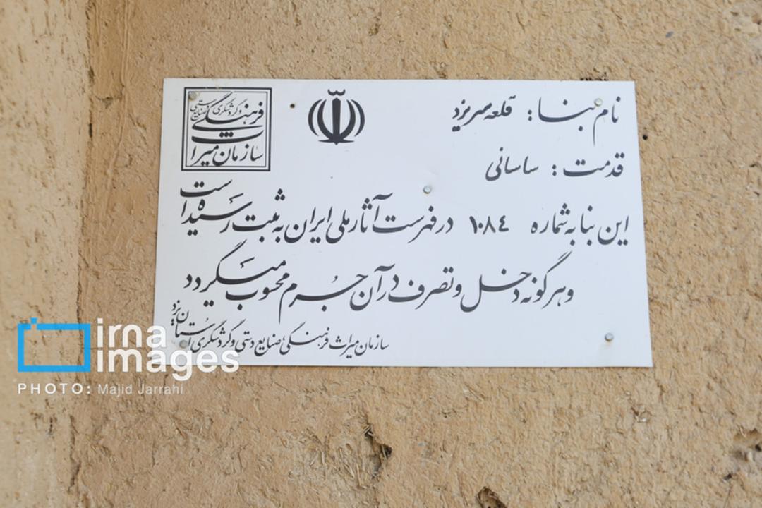 لوح سفید حاوی اطلاعات تاریخی قلعه سریزد روی دیوار خشتی