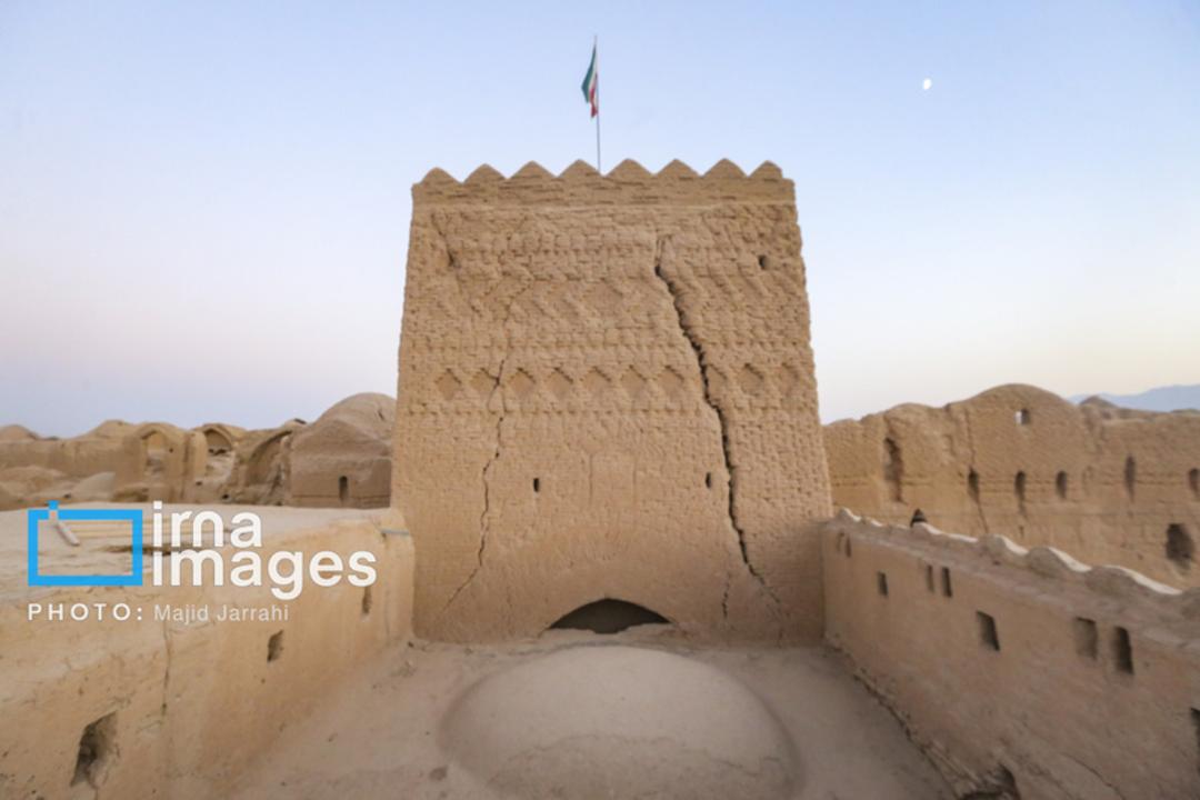 برج خشتی قلعه سریزد (Sarizad) با پرچم ایران در پس‌زمینه کویر