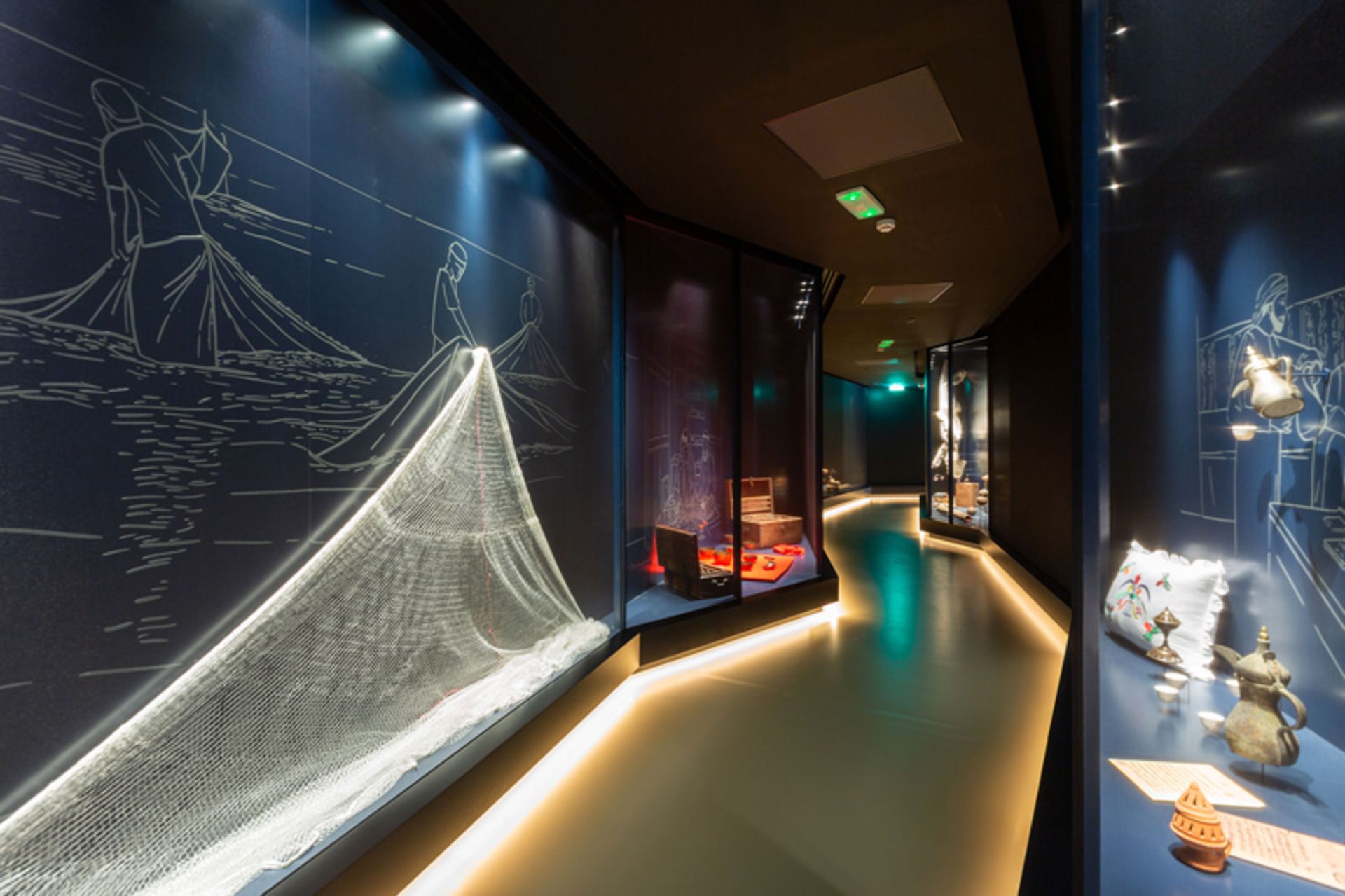 نمای داخلی موزه دبی با قفسه های روشن و طرح هایی بر دیوار