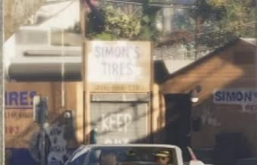 تابلوی سفید رنگ مغازه لاستیک سیمونز (Simon's Tires) در خیابان