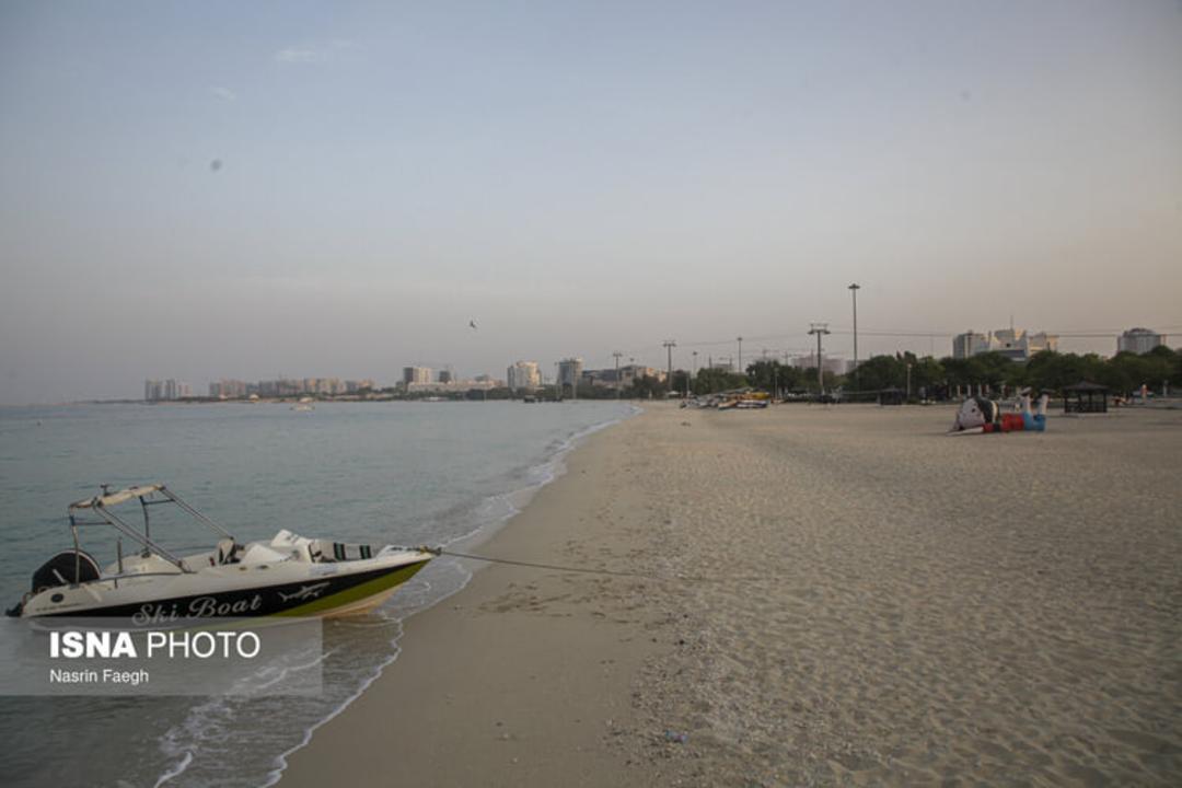 قایق تفریحی (Ski Boat) در لبه ساحل ماسه‌ای کنار آب