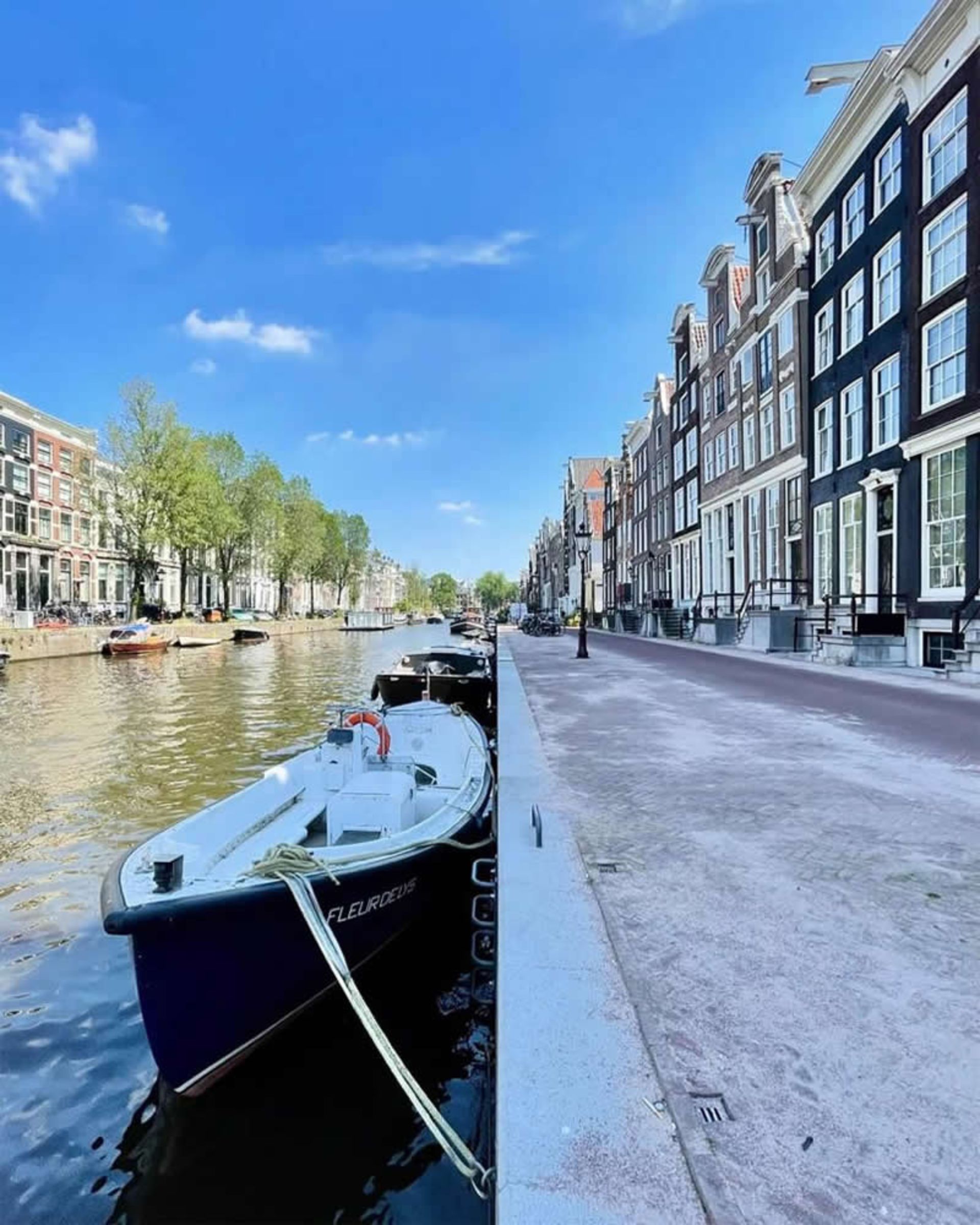 قایقی در رودخانه آرام کنار ساختمان های مدرن