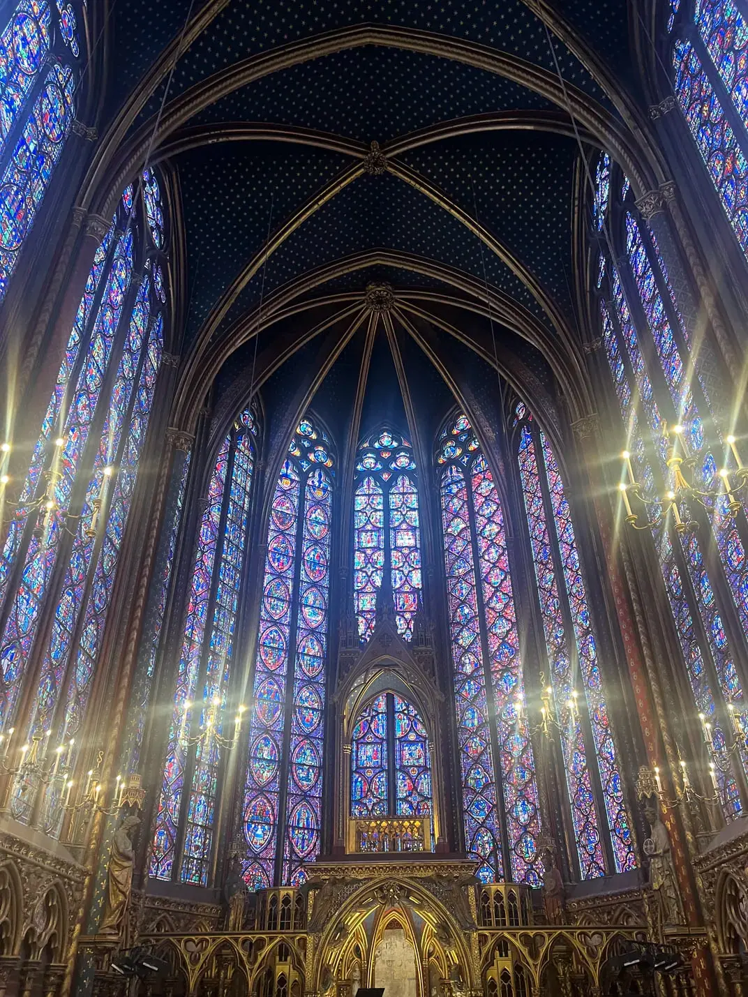 پنجره‌های رنگی (Stained Glass) در فضای داخلی یک کلیسای گوتیک با سقف بلند