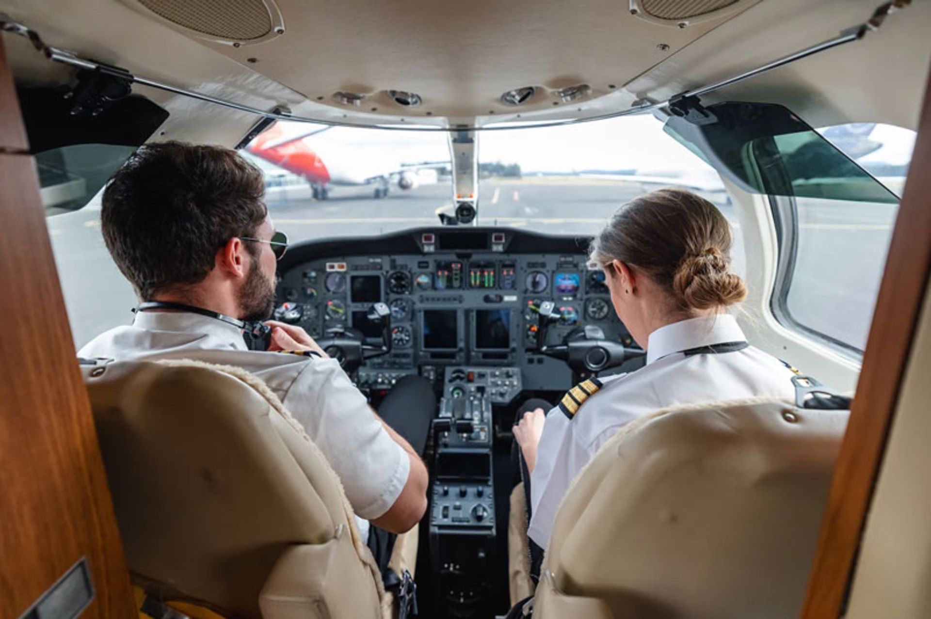 دو خلبان در کابین خلبان روی باند فرودگاه