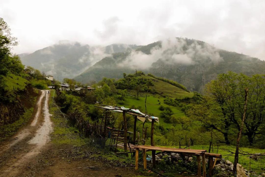 کوهستان‌های مه‌آلود و جاده خاکی روستایی در منطقه تالش