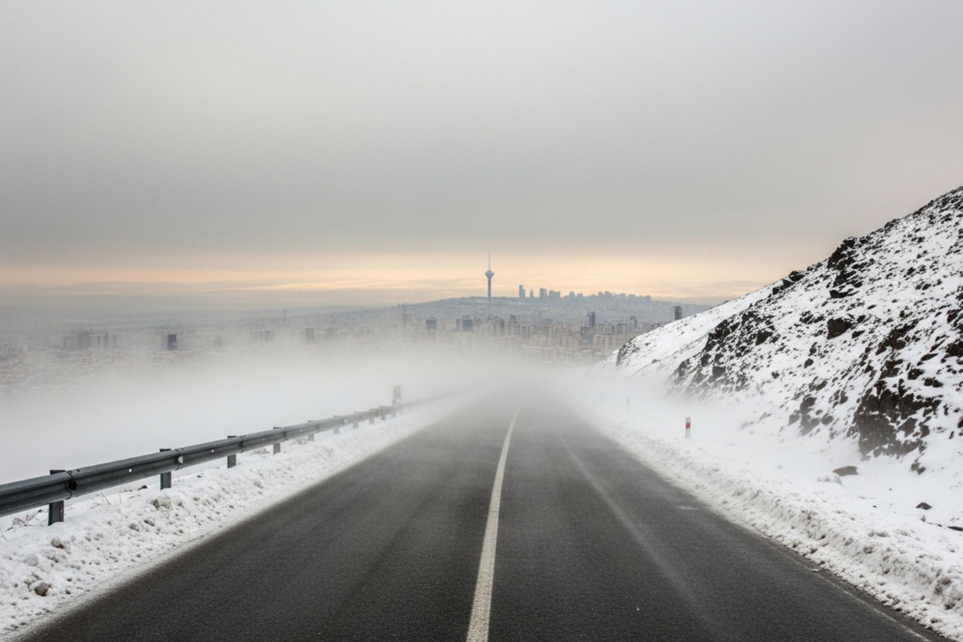 جاده کوهستانی پوشیده از برف در یک روز طوفانی