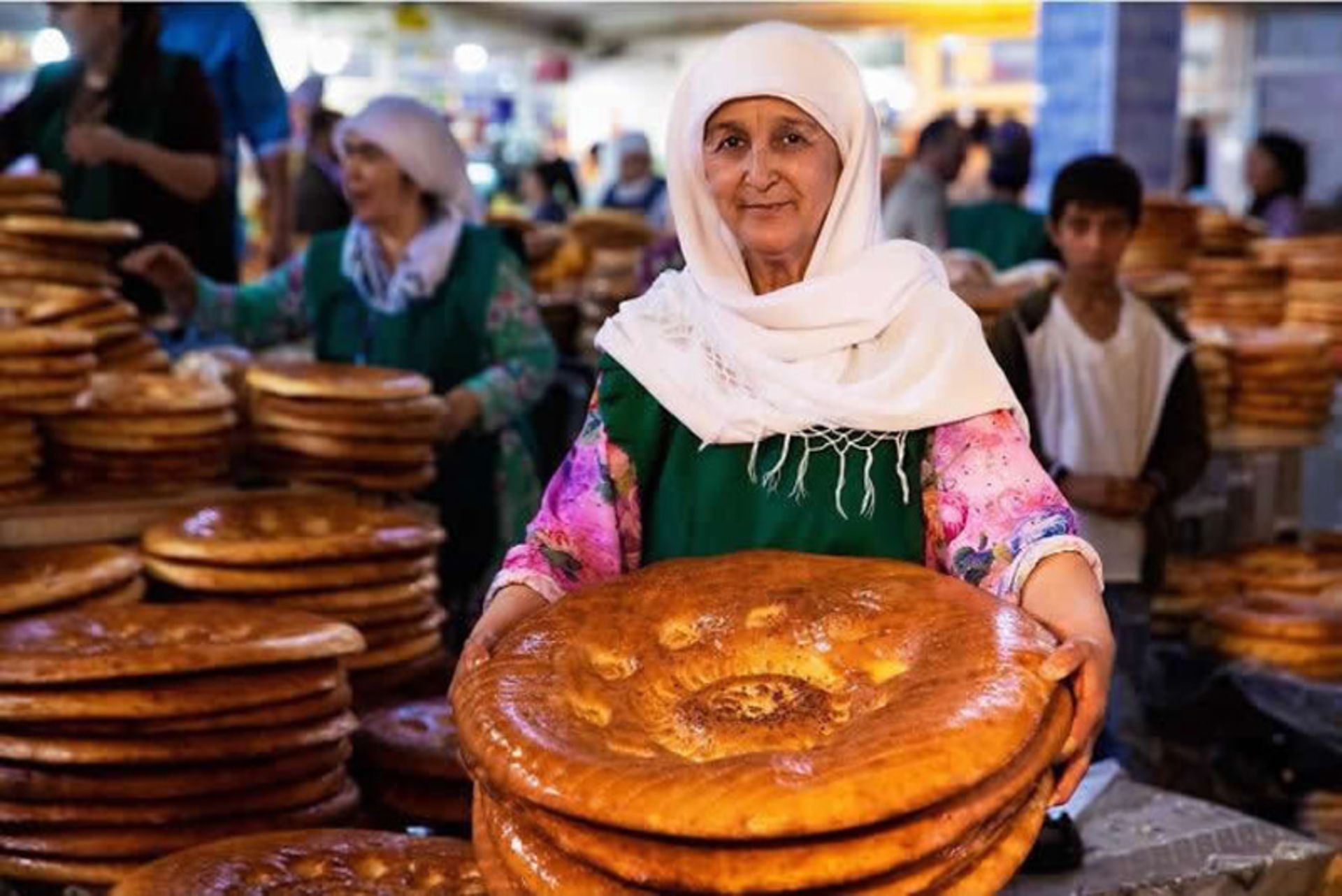 زن مسن محجبه در حال فروش نان محلی