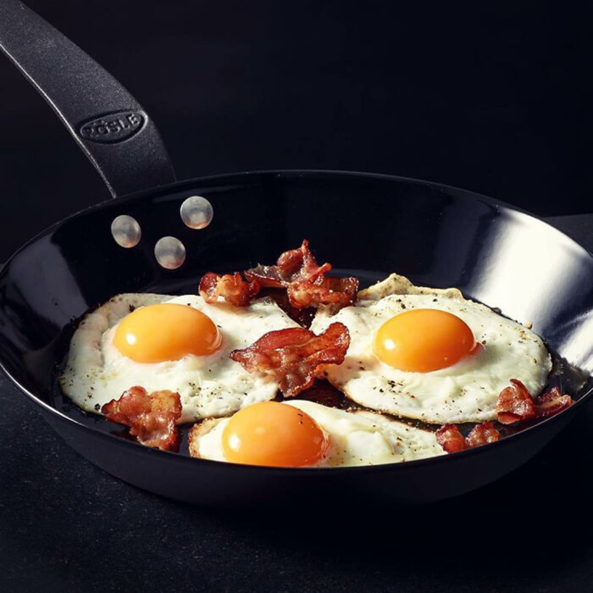 ماهیتابه با سه تخم مرغ نیم رو و تکه های بیکن