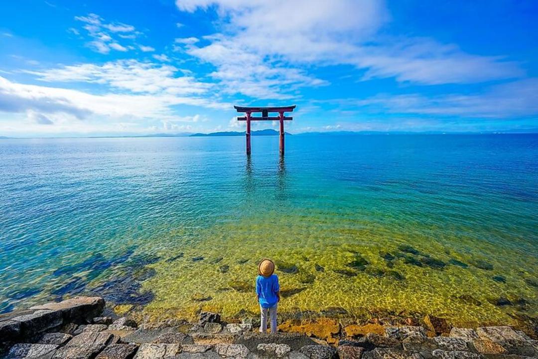 دروازه توئی (Torii) قرمز رنگ در میان آب‌های شفاف دریا