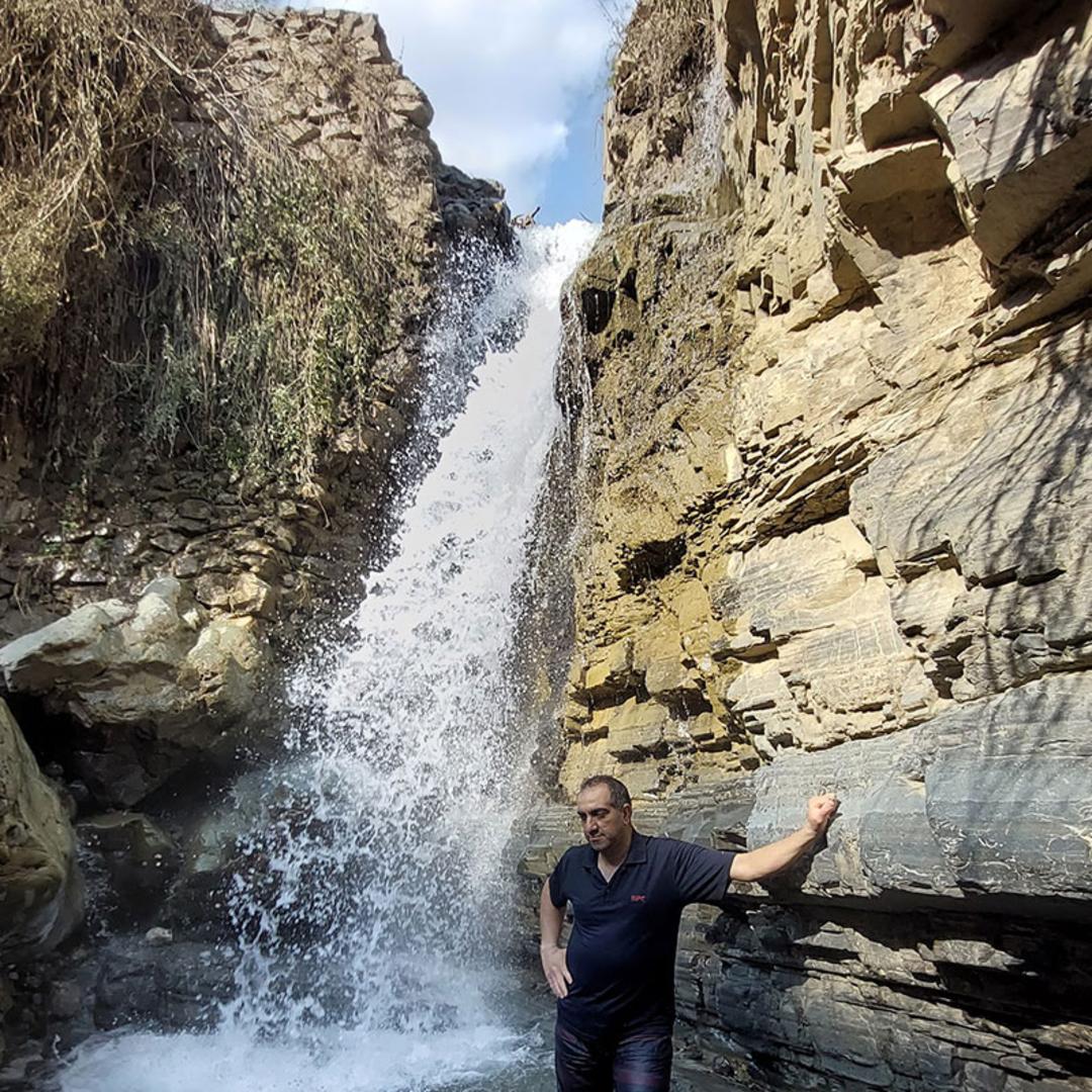 گردشگر مرد در کنار آبشار سیبان دره
