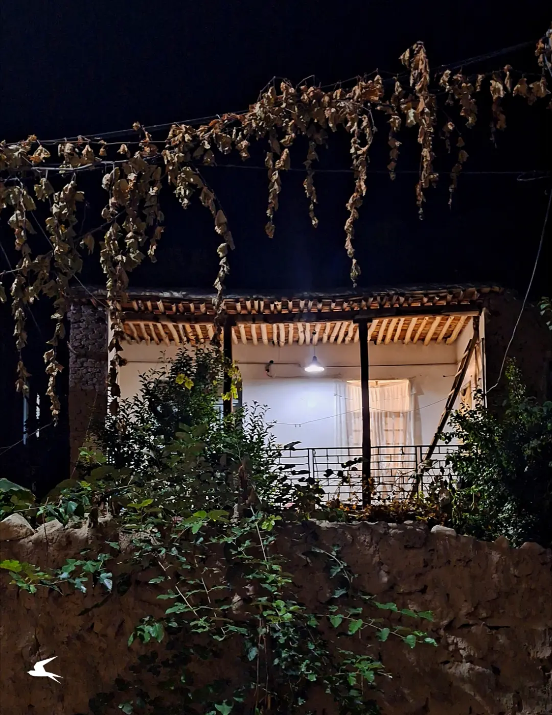 خانه قدیمی روستای اسطرخی با ایوان چوبی در شب