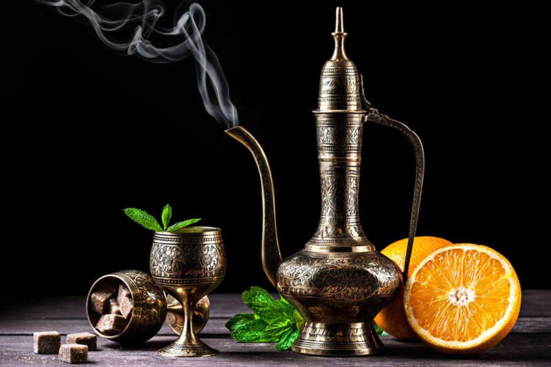 ظروف مسی سنتی چای همراه با تکه‌های شکر و پرتقال