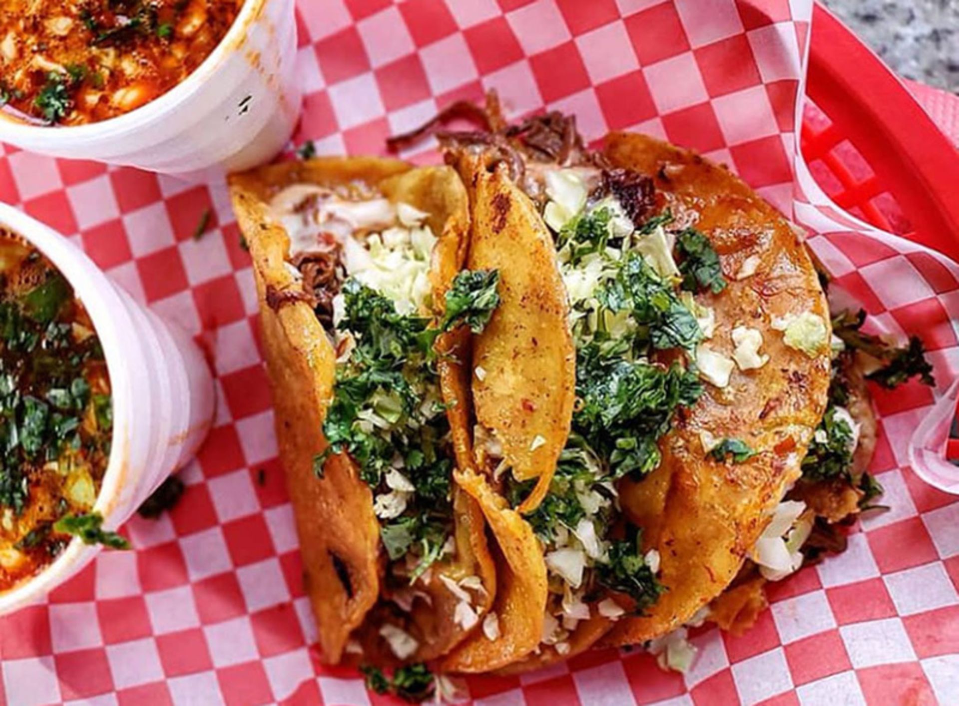 دو ساندویچ تاکو در سفره ای چهارخانه