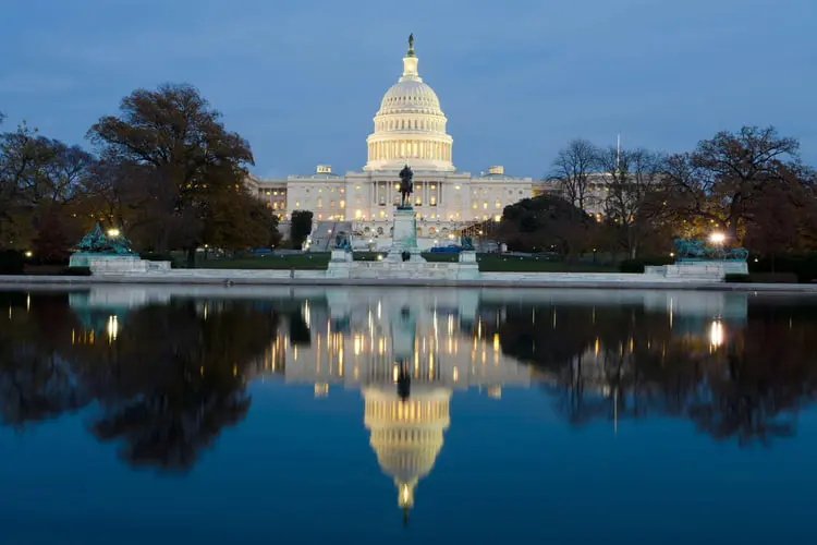 ساختمان کنگره ایالات متحده (United States Capitol) در مقابل برکه در هنگام غروب