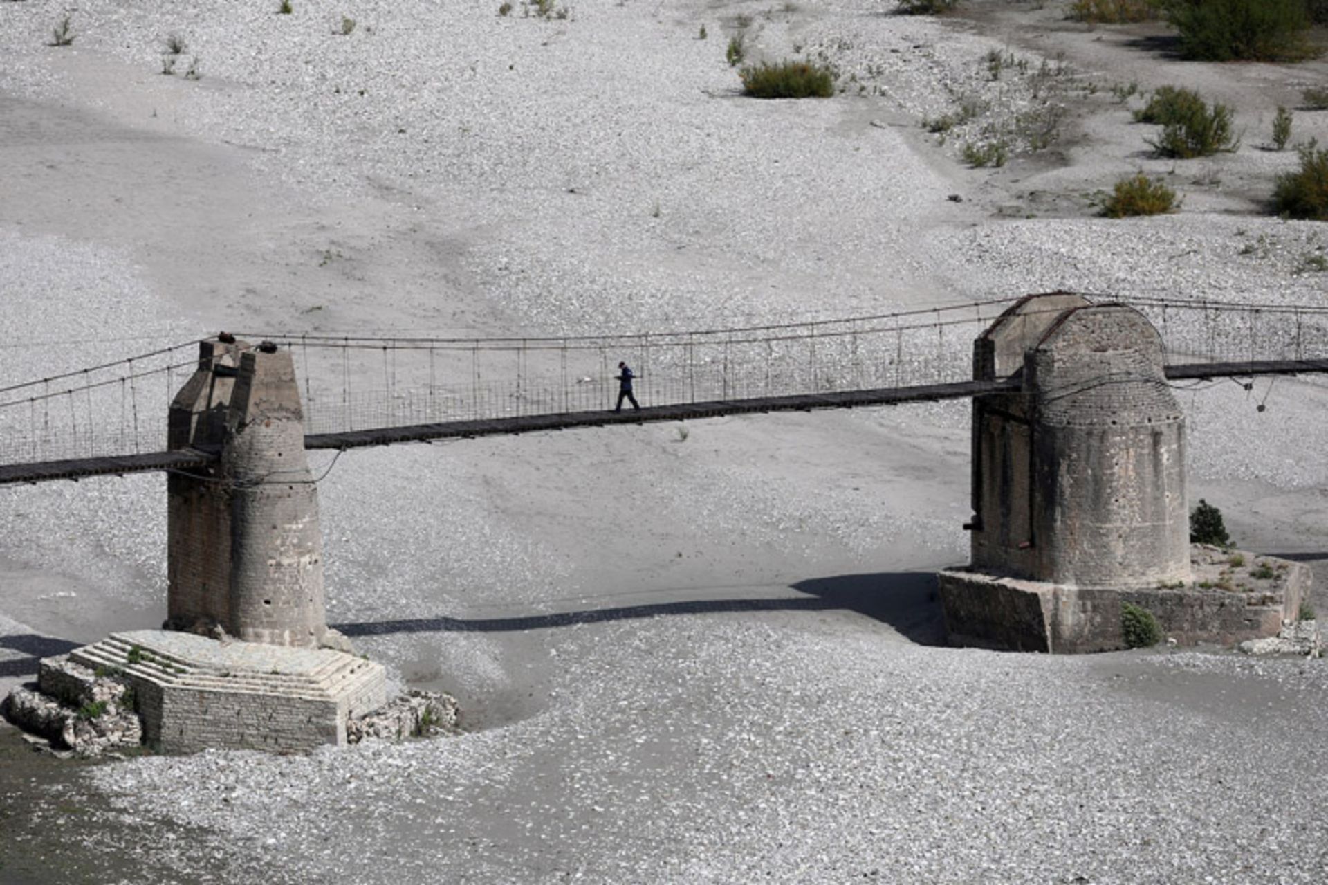 پیاده‌روی مردی روی پل در دره ویوسا (Vjosa)، آلبانی