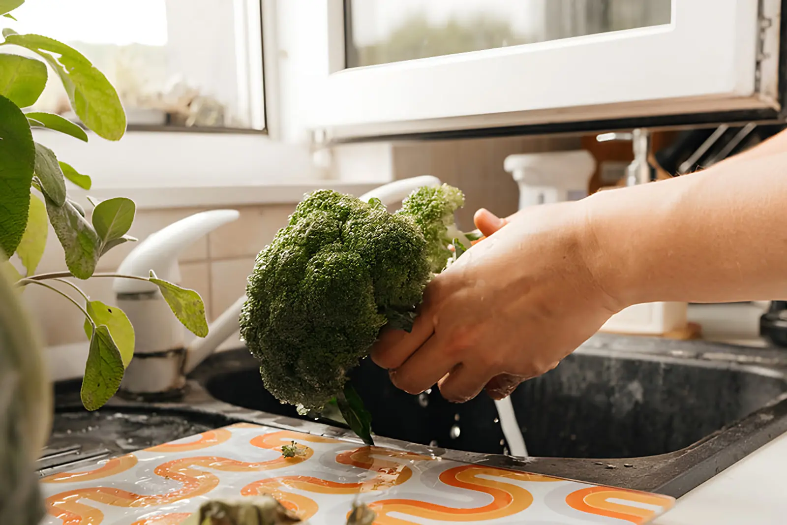 کلم بروکلی (Broccoli) تازه زیر جریان آب شیر در سینک ظرفشویی