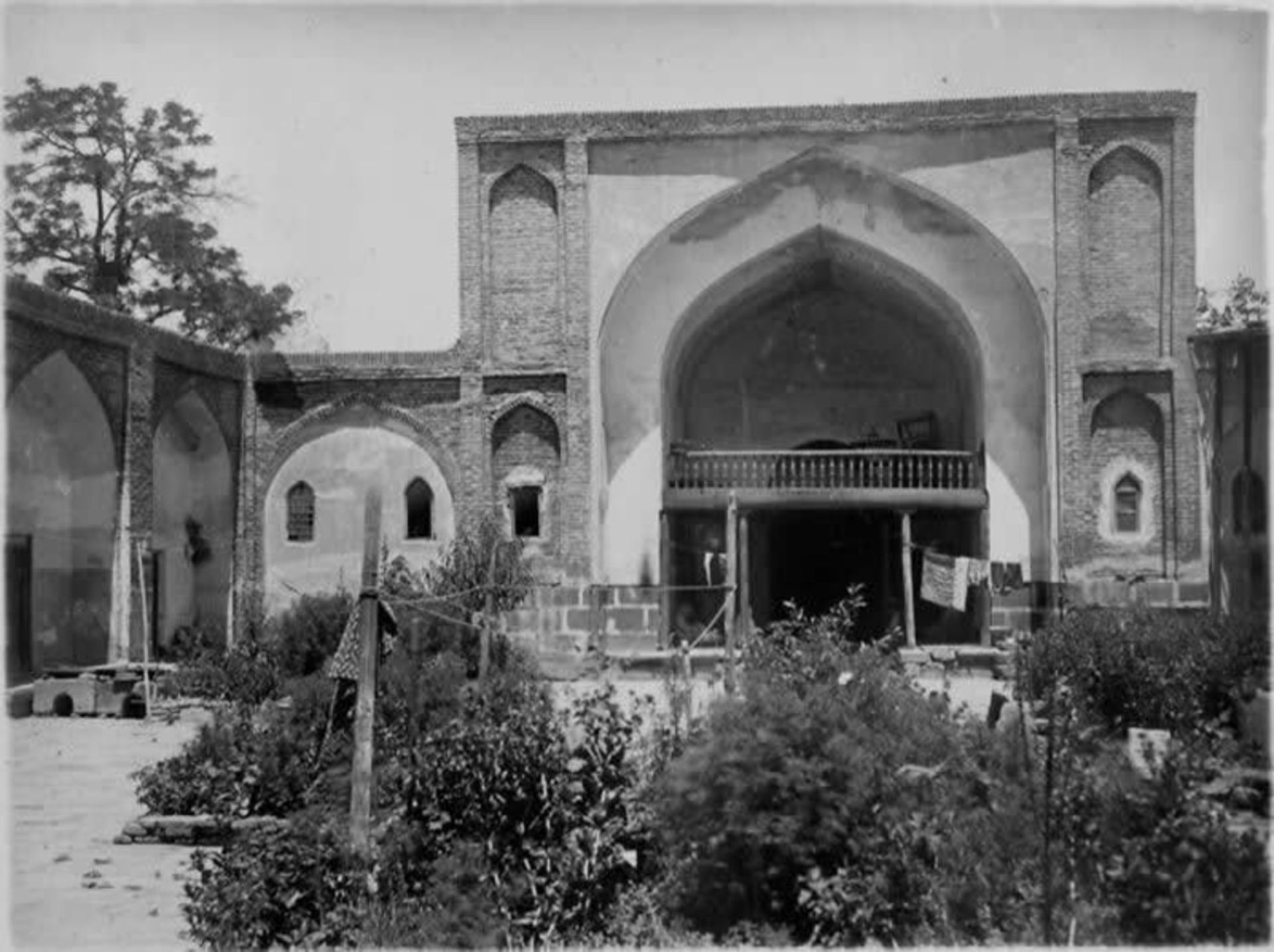 حیاط داخلی یک مدرسه تاریخی در ایروان با سازه آجری و باغچه گلکاری شده
