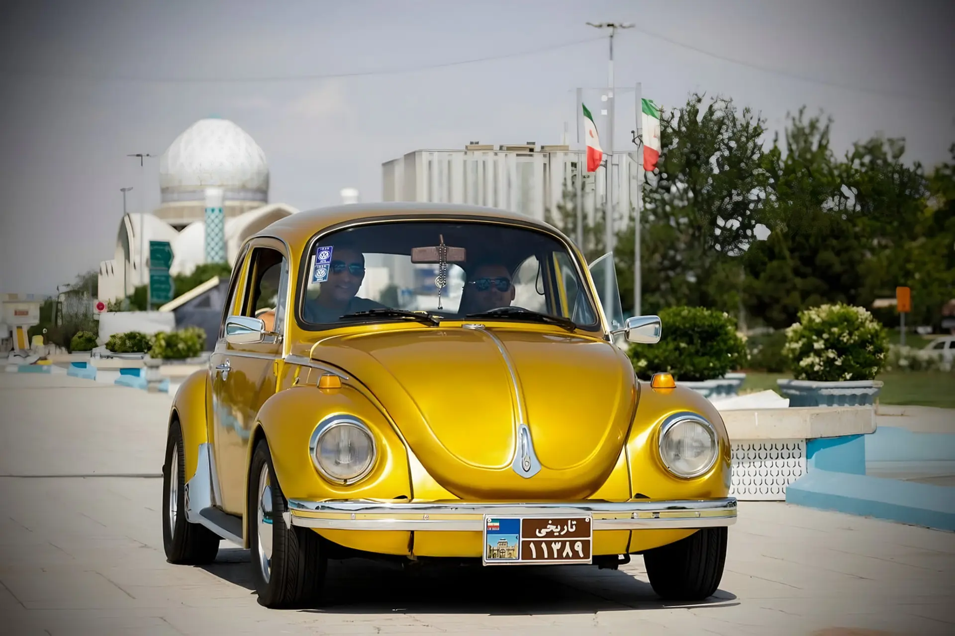 خودرو فولکس‌واگن (Volkswagen Beetle) زرد رنگ با پلاک تاریخی در خیابان